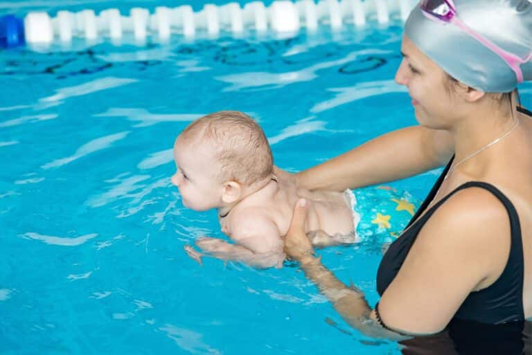 bébé dans l'eau avec une adulte